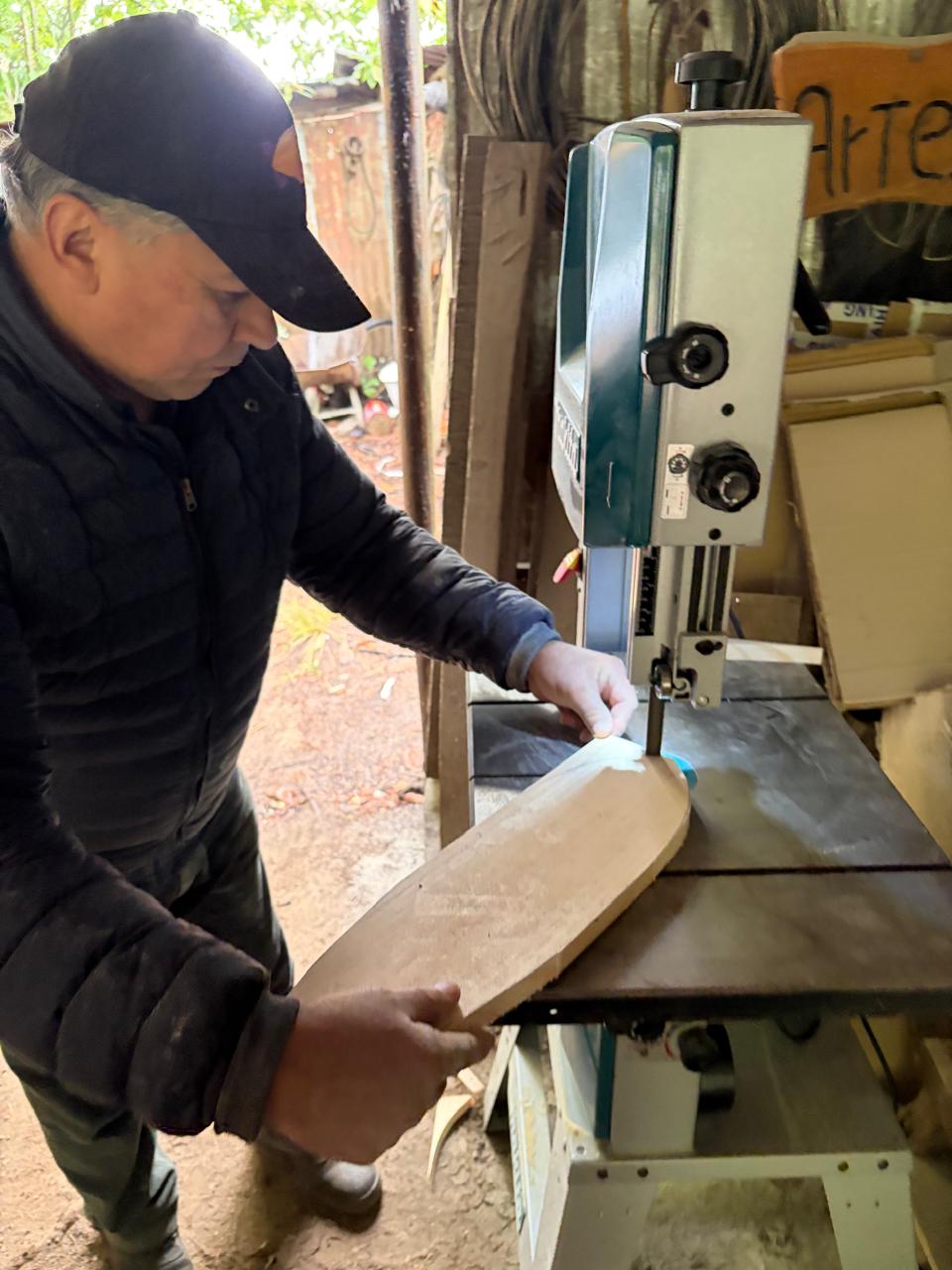 Edgardo cortando madera con sierra de cinta