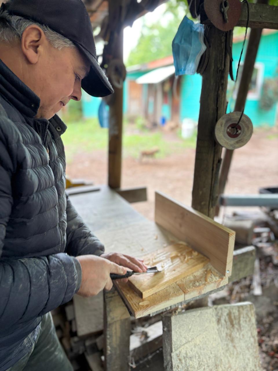Edgardo Burgos cepillando madera en su taller