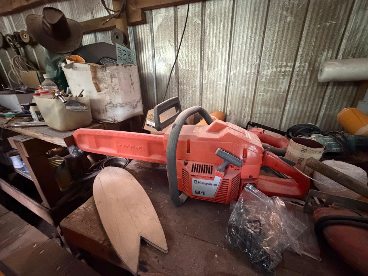 Taller con motosierra Husqvarna y piezas de madera